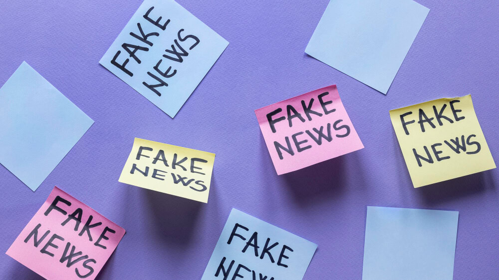 Haftnotizen mit der Aufschrift „FAKE NEWS“ sind kunstvoll auf einem leuchtend violetten Hintergrund angeordnet und setzen so ein eindrucksvolles visuelles Statement.