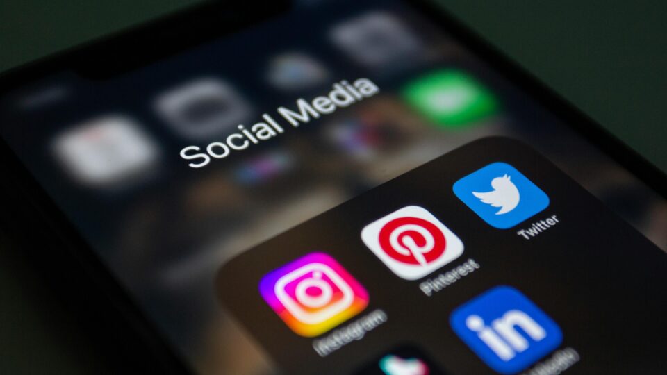 Auf einem Smartphone-Bildschirm wird ein Ordner mit der Bezeichnung „Social Media“ mit App-Symbolen für Instagram, Pinterest, Twitter und LinkedIn angezeigt – wichtige Plattformen für Social Media Branding und effektive Markenführung.