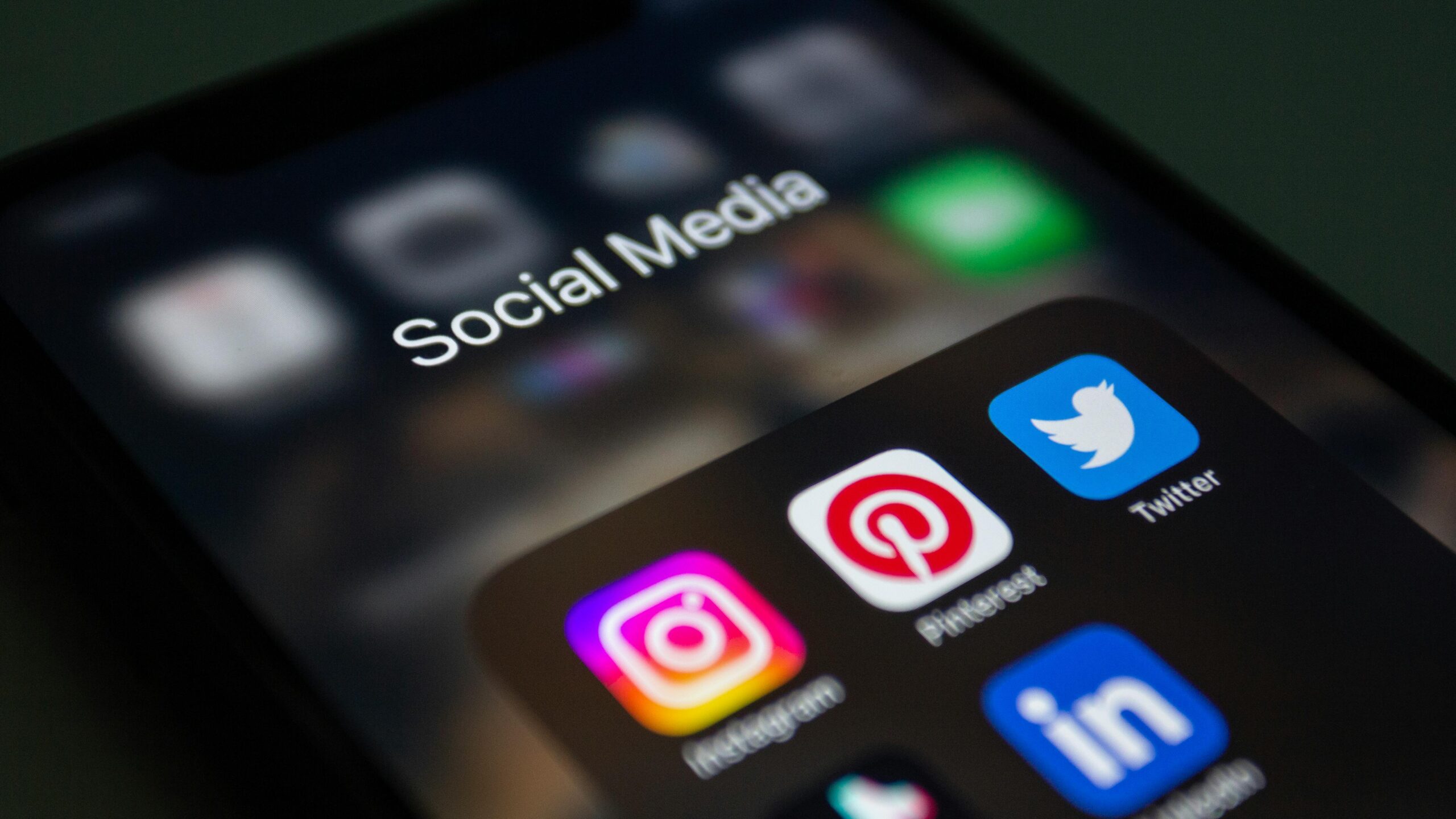 Auf einem Smartphone-Bildschirm wird ein Ordner mit der Bezeichnung „Social Media“ mit App-Symbolen für Instagram, Pinterest, Twitter und LinkedIn angezeigt – wichtige Plattformen für Social Media Branding und effektive Markenführung.