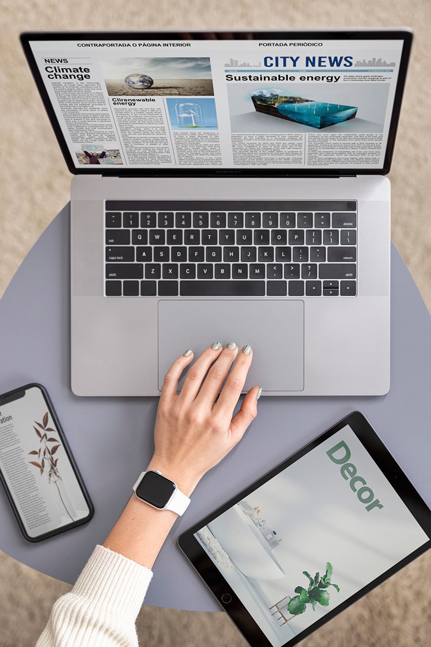 Eine Person sitzt an einem Tisch mit einem Laptop, auf dem Nachrichten mit Native Ads angezeigt werden, während auf einem Smartphone und einem Tablet Dekorations- und Pflanzenartikel zu sehen sind.